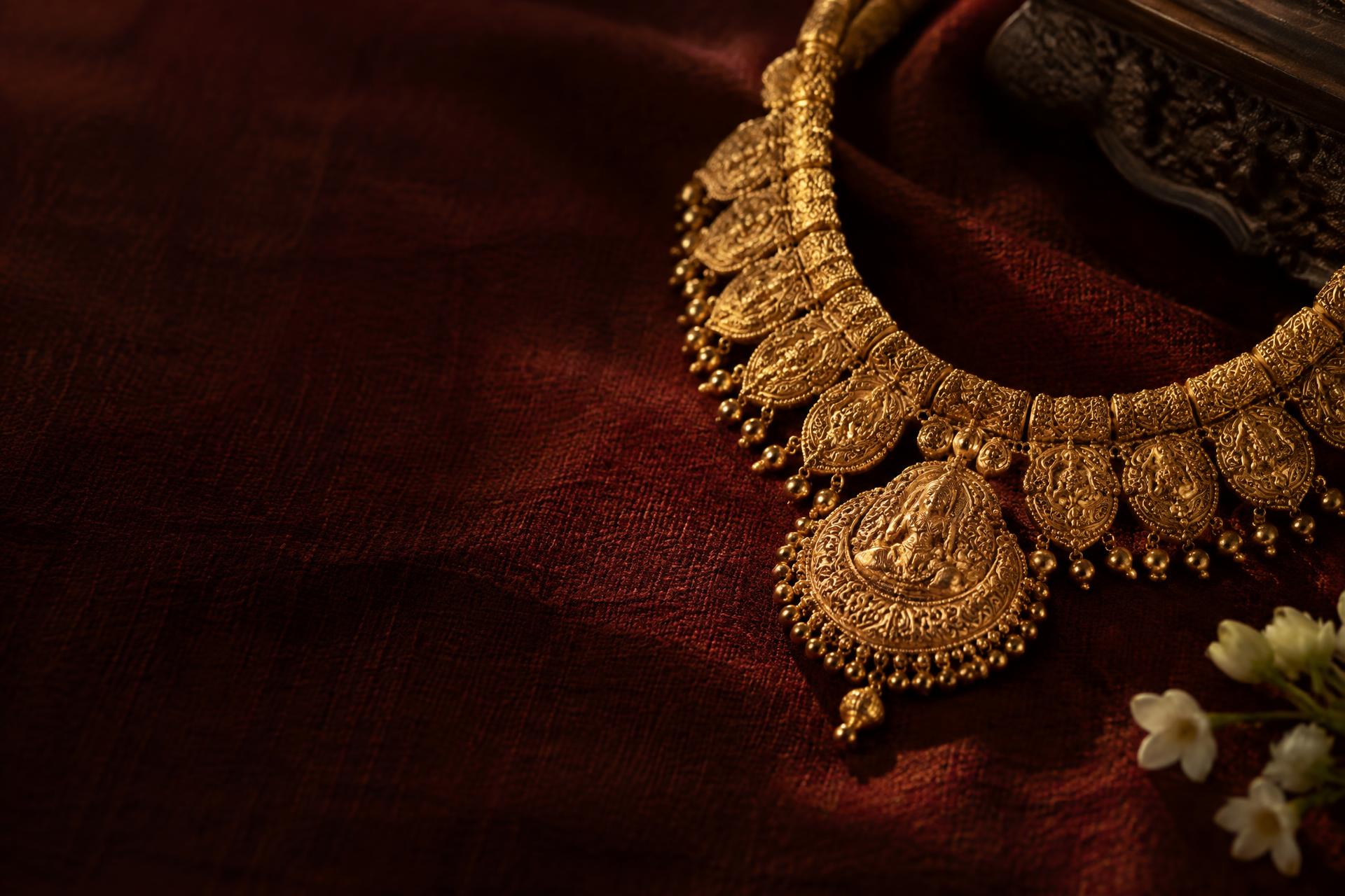 Traditional gold necklace on burgundy fabric